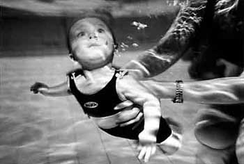 Una bimba di sei mesi a un corso di nuoto in una piscina per bambini a nord di Londra. Inghilterra, maggio 2002